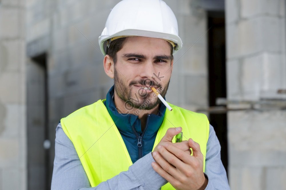 Photo Of A Builder Smoking Cigarette On A Construction Site With A