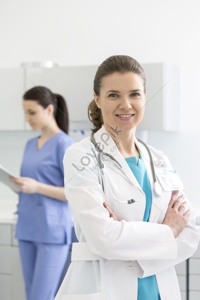 Portrait Of A Smiling Doctor With Arms Crossed Standing Beside A Nurse