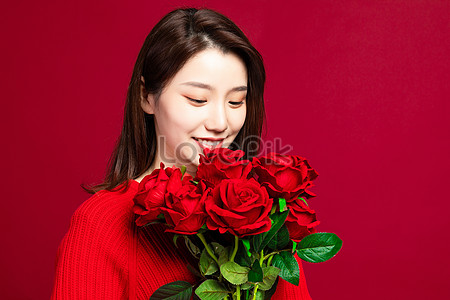 Middle age woman holding roses flowers on pot pointing with hand and finger  up with happy face smiling Stock Photo