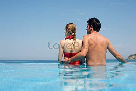 A young couple in swim wear, touching, being romantic. A couple romantic  beach lifestyle concept Stock Photo - Alamy