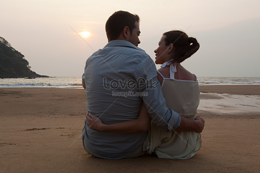 Đôi vợ chồng đang tận hưởng khoảnh khắc trên bãi biển hoàng hôn với ánh nắng tuyệt đẹp cùng cảnh sắc thơ mộng. Hình ảnh này sẽ khiến bạn muốn đắm mình trong không gian lãng mạn và hạnh phúc bên người yêu.