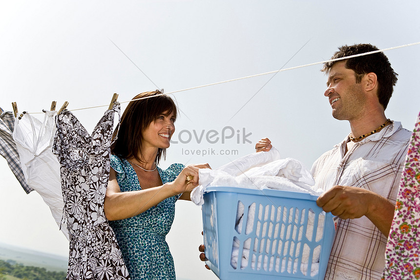 Man Helps Woman Hang Clothes. 