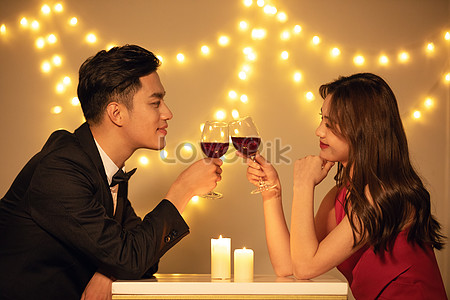 Standing and holding big glasses with wine. Young lovely couple have romantic  dinner indoors together 15350870 Stock Photo at Vecteezy