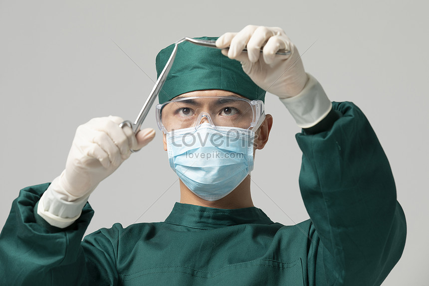 Male Doctor In Surgical Gown Holding Surgical Scissors Picture And HD ...