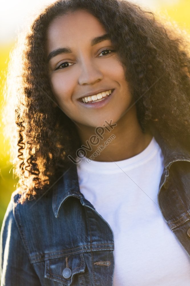 Portrait of happy African American teen girl looking at camera at home,  headshot of smiling black teenager posing indoors, beautiful mixed race  teenage female laughing making picture Stock Photo
