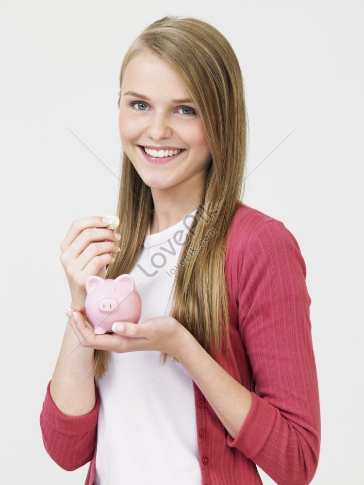 A Teenage Girl Putting Money Into A Piggy Bank Picture And HD Photos ...