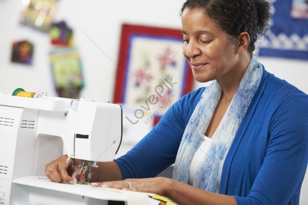 A girl is sewing on a machine. Mom shows how to work with equipment.  Close-up. Stock Photo by ©Alexeg84 314794668