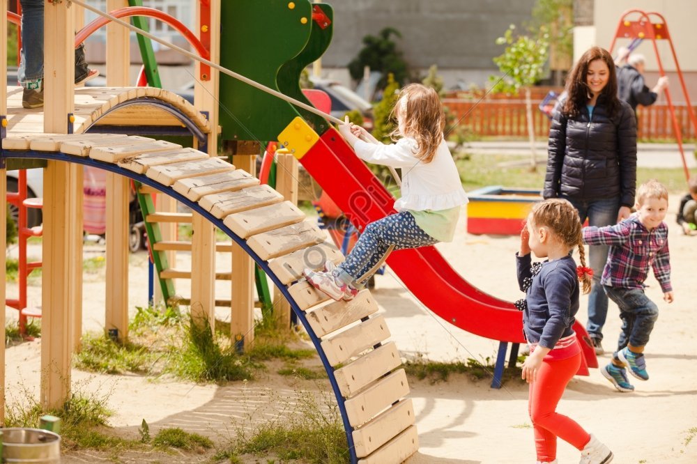 Los niños pequeños correr y jugar en el parque infantil. Centro de juego  para los niños. Niña es jugar al aire libre. El concepto de verano los  niños Fotografía de stock 