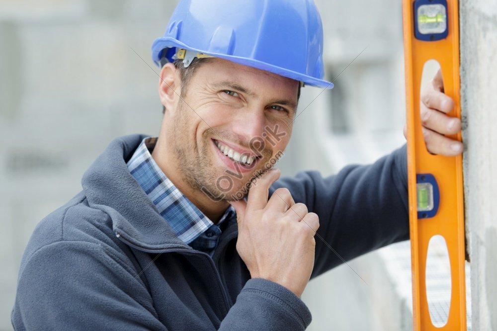 Happy Builder Posing With Spirit Level At Construction Site Snapshot ...