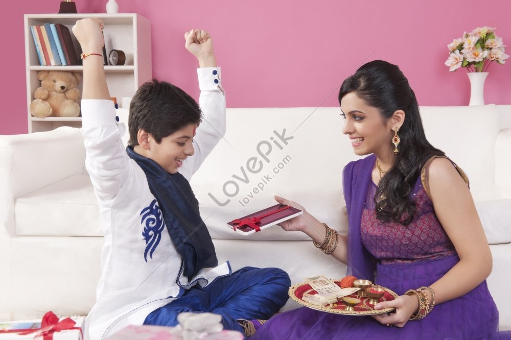 Cute Indian boy and girl celebrating festival and sharing gifts. Its a  front facing photo in which brother sister duo spending family time and  enjoying fun moments. Stock Photo | Adobe Stock