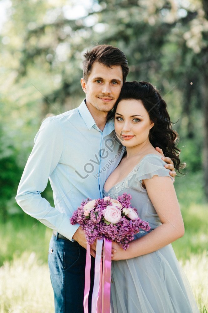 Un Chico Y Una Chica Caminando En Un Jardín Primaveral De Lilas Para Fotos  Previas A La Boda Foto