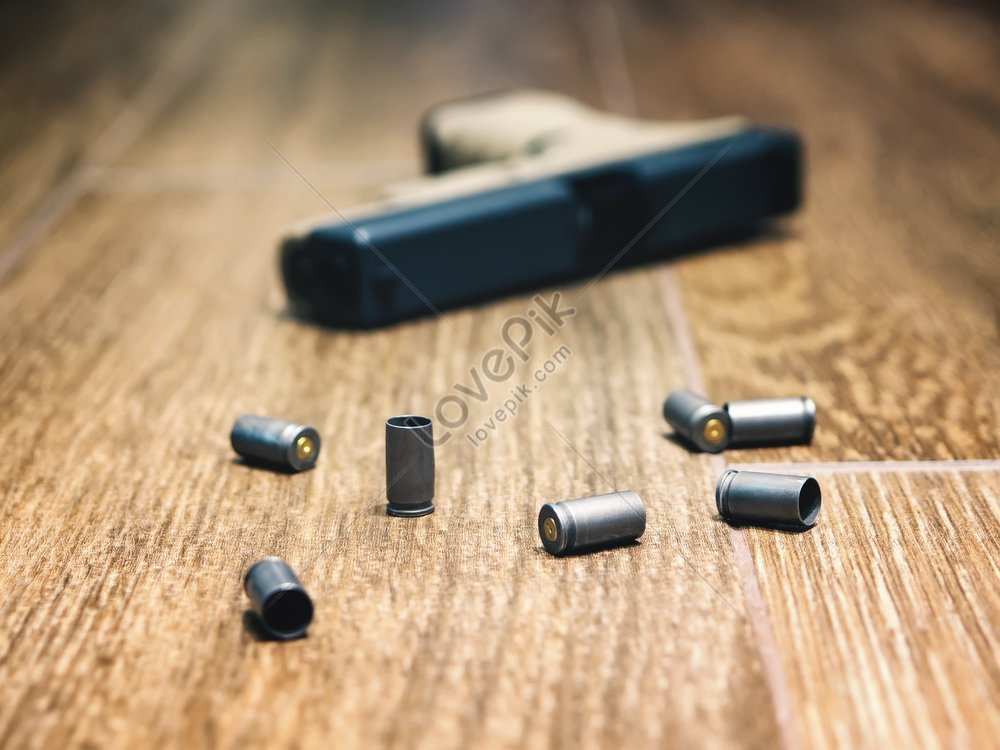 Defocused 9mm Semi Auto Pistol On The Floor Surrounded By Spent Shells ...