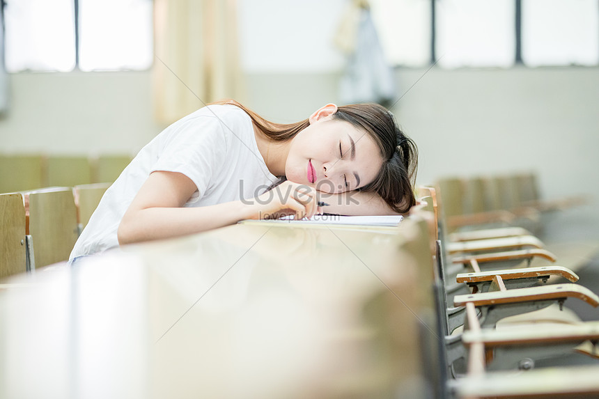 A Student Sleeping On The Desk Of The Classroom Photo