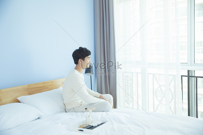 寝室のベッドのそばに座っている若い男性イメージ 写真 Id Prf画像フォーマットjpg Jp Lovepik Com