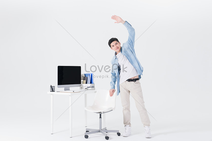 Young Employees Stretch Out At Their Desks Photo Image Picture