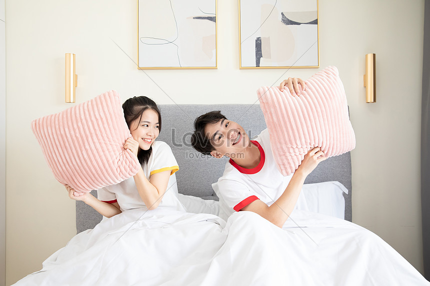 Cute Couple Playing With Pillows On The Bed Picture And HD Photos