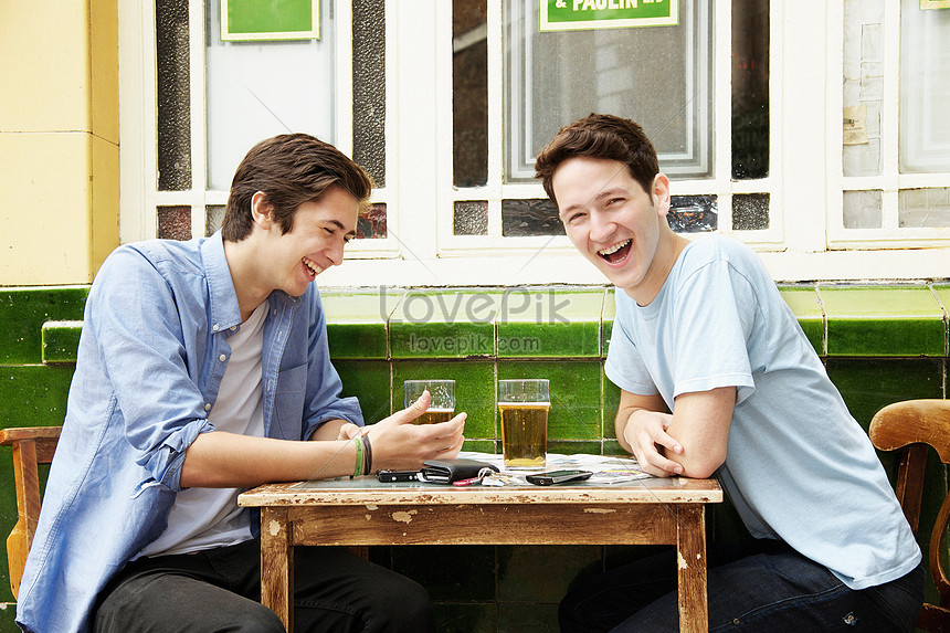 Pria Yang Tersenyum Sedang Minum Bir Di Kafe Gambar Unduh Gratis