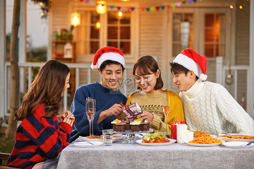 Young People Give Each Other Christmas Gifts On Christmas Eve Picture ...