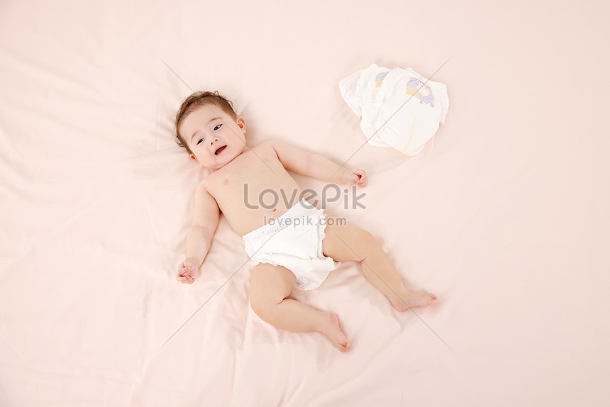 Two-year old boy with pants down wearing diapers, Stock Photo